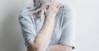 A woman metaphorically trapped in a spider web depicting anxiety and entrapment.