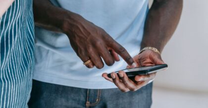 Close-up of a person interacting with a smartphone, captured indoors in a casual setting.